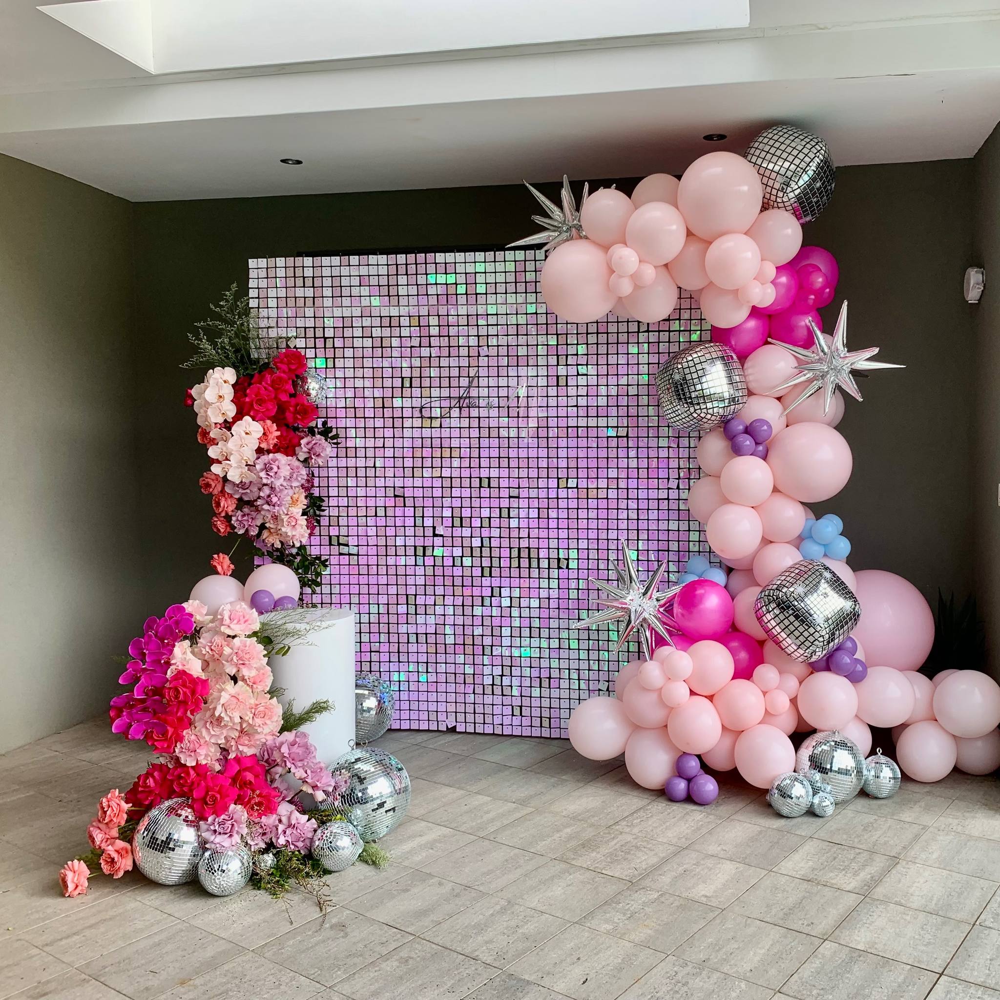 Pink and silver disco-style backdrop with balloon flowers and centrepiece