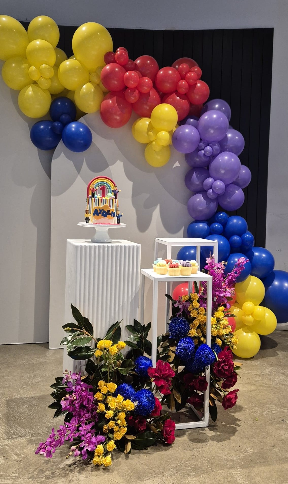 Vibrant birthday setup with balloons, florals, and a custom plaque
