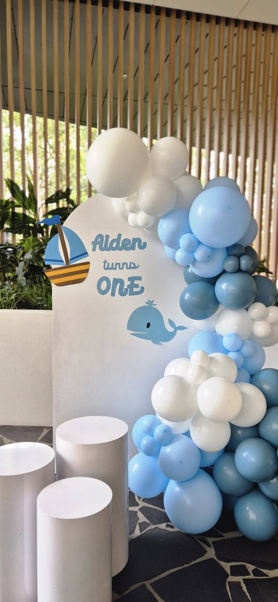 One year birthday with whale theme, blue balloons, and custom plaque